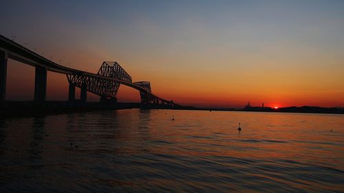 Tokyo gate bridge over tokyo bay against sky during sunset