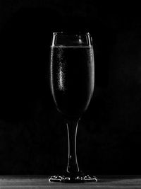 Close-up of wineglass on table against black background