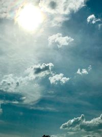 Low angle view of sunlight streaming through clouds