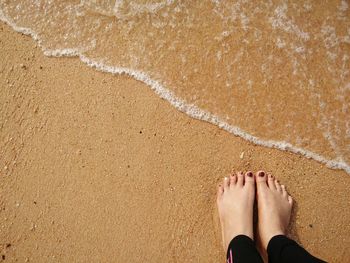 Low section of woman on sand