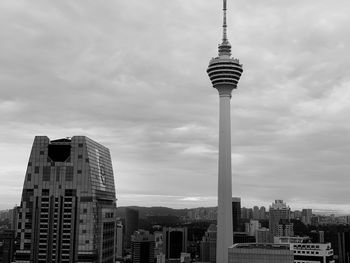 View of buildings in city against cloudy sky