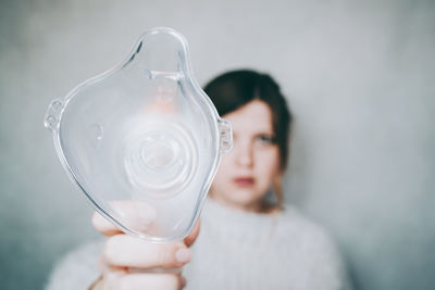 Close-up portrait of woman holding white glass