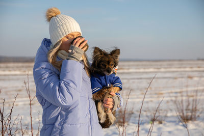 Rear view of woman with dog on field