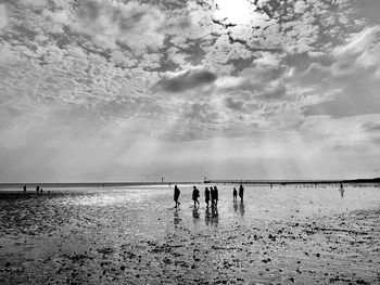 People on beach against sky