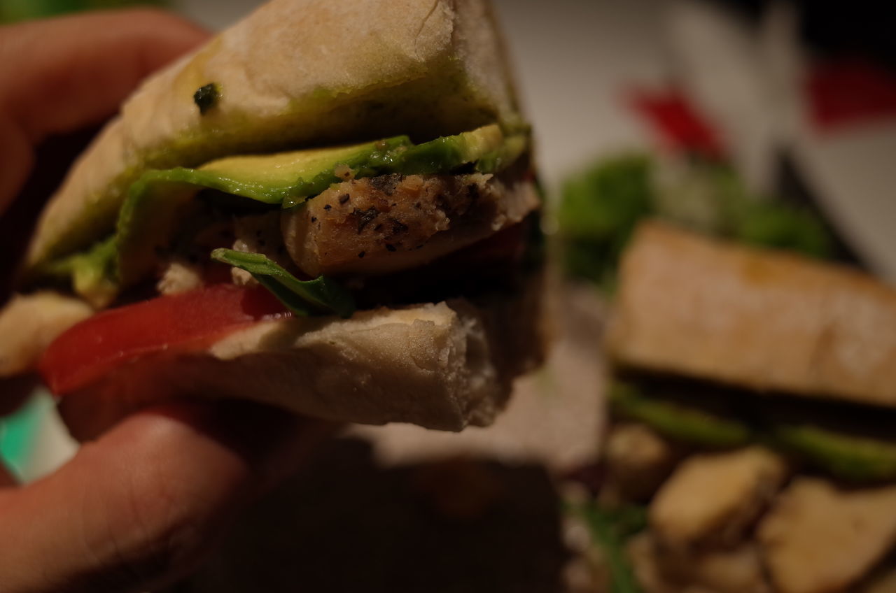 food and drink, human hand, food, sandwich, hand, freshness, bread, fast food, close-up, burger, human body part, ready-to-eat, meat, indoors, one person, vegetable, unhealthy eating, unrecognizable person, focus on foreground, selective focus, hamburger, finger, take out food, snack