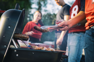 People preparing food on barbecue grill