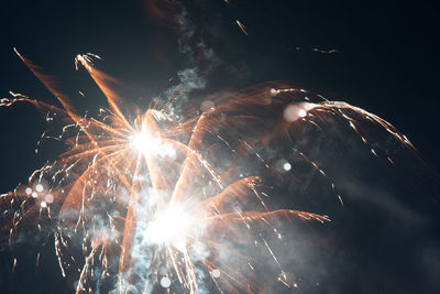 Low angle view of firework display at night