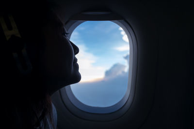 Woman looking through airplane window