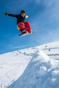 Man jumping with snowboard on landscape