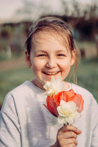 Close-up portrait of a girl holding pink flower