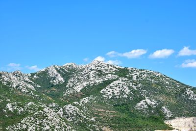 Low angle view of mountain against blue sky