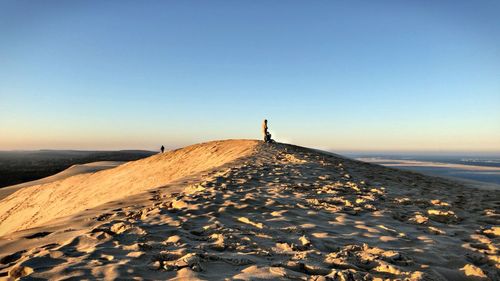 Man on beach against clear sky