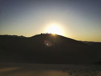 Scenic view of silhouette mountain against clear sky during sunset