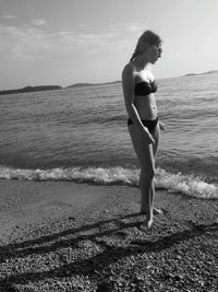 Full length of young woman standing on beach