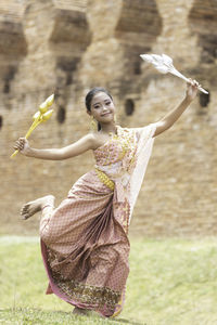 Portrait of a smiling young woman holding plant