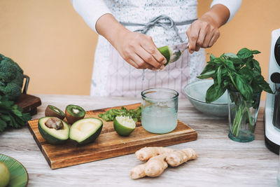 Midsection of woman preparing food on cutting board