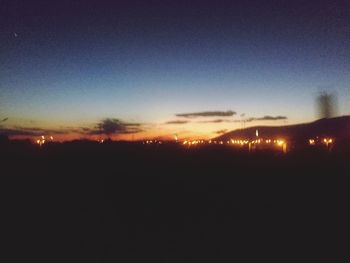 Silhouette landscape against clear sky at night
