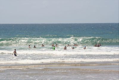 People at beach against clear sky