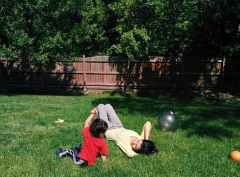 Full length of girl relaxing on grassy field in park