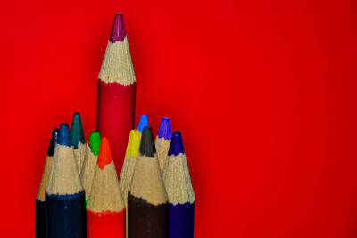 Close-up of colored pencils against red background