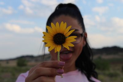 Close-up of teenage girl holding sunflower against her face