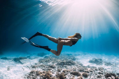 Low section of woman swimming in sea