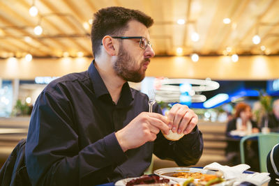 Young man eating in restaurant