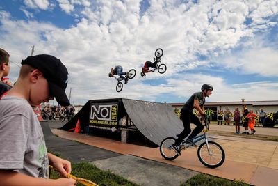 People riding bicycle against sky