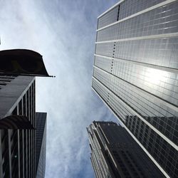 Low angle view of modern building against cloudy sky