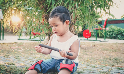 Boy playing with man sitting outdoors