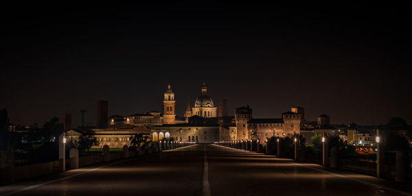 Illuminated buildings in city against sky at night