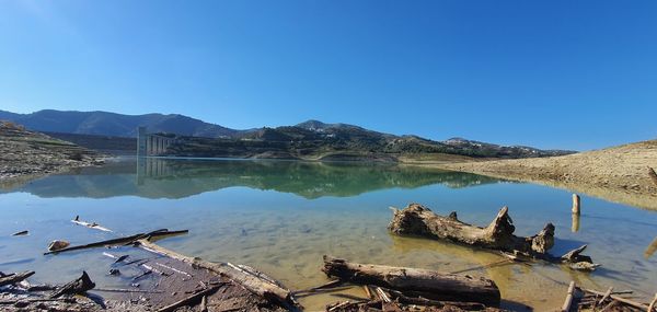 Panoramic view of lake and mountains against clear blue sky