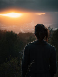 Rear view of woman looking at sunset