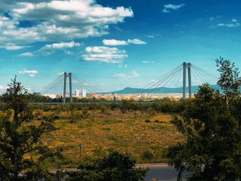 View of suspension bridge against cloudy sky