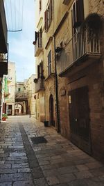 Cobblestone street amidst buildings in city