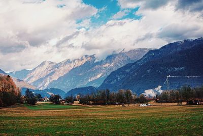 Scenic view of field and mountains against sky