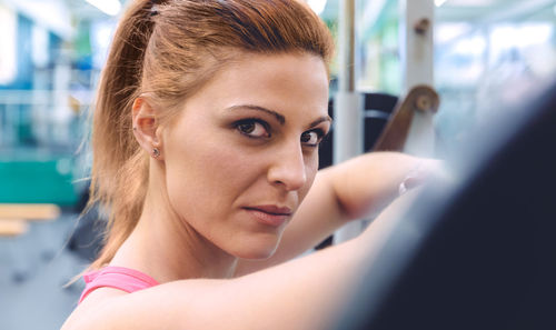 Portrait of woman lifting barbell in gym