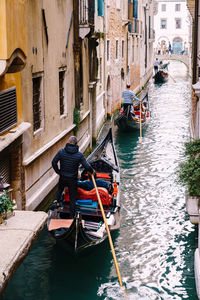 High angle view of boats in canal along buildings