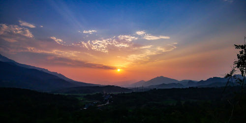 Scenic view of silhouette mountains against sky during sunset