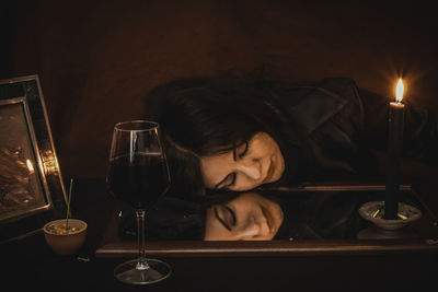 Portrait of woman with red wine glass on table