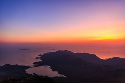 Scenic view of silhouette mountains against romantic sky at sunset