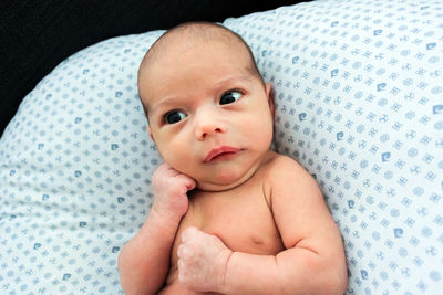 Portrait of cute baby lying on bed