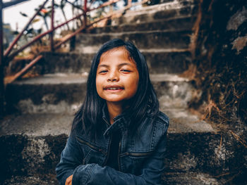 Portrait of smiling girl sitting on steps