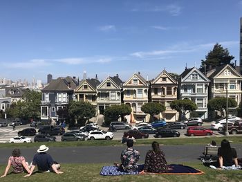 Group of people on buildings in city against sky