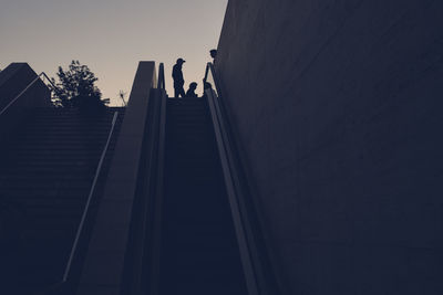 Low angle view of silhouette people on staircase against sky