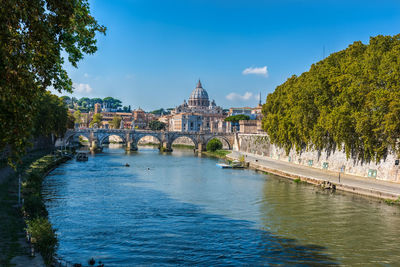 Arch bridge over river against blue sky