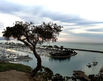 Boats in sea against cloudy sky