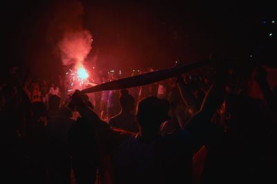 People watching firework display at night