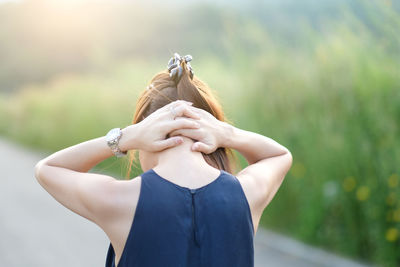 Rear view of woman with arms raised