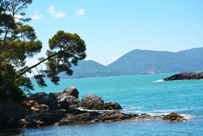 Scenic view of sea and mountains against sky